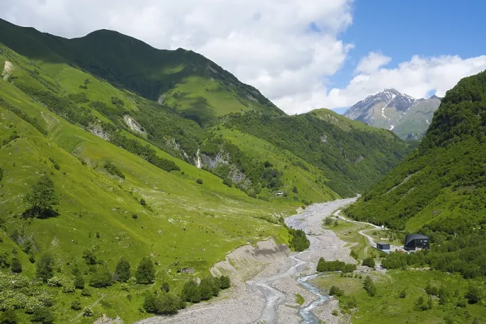 Framed Print : Wide mountainous landscape with river surrounded by lush greenery under a cloudy sky