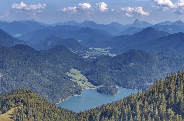 Framed Print : A wide panorama of mountains and valleys with extensive forests under a blue sky with clouds