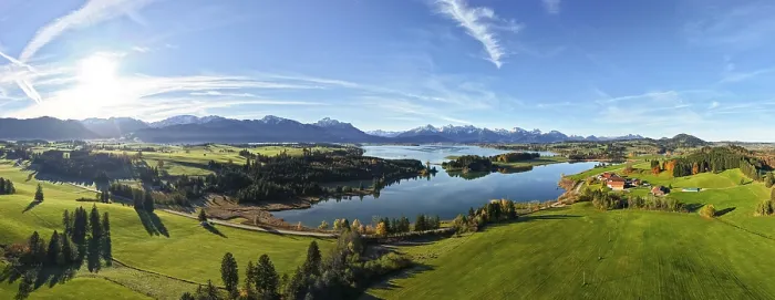 Framed Print : Wide panoramic view of a green landscape with lake and mountain backdrop under clear sky Framed Print : Wide panoramic view of a green landscape with lake and mountain backdrop under clear sky