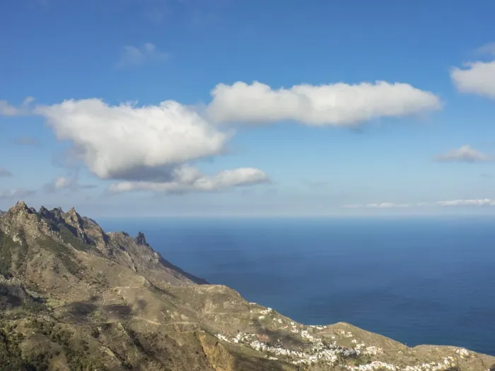 Framed Print : Wide view over mountains to the deep blue sea under a sky with scattered clouds Framed Print : Wide view over mountains to the deep blue sea under a sky with scattered clouds