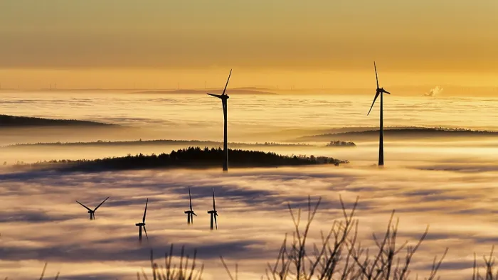 Framed Print : Wind turbines and forest rising from cloud cover