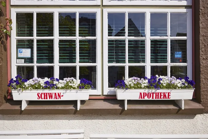 Framed Print : Window with flower boxes of the Swan pharmacy in the city centre of Husum