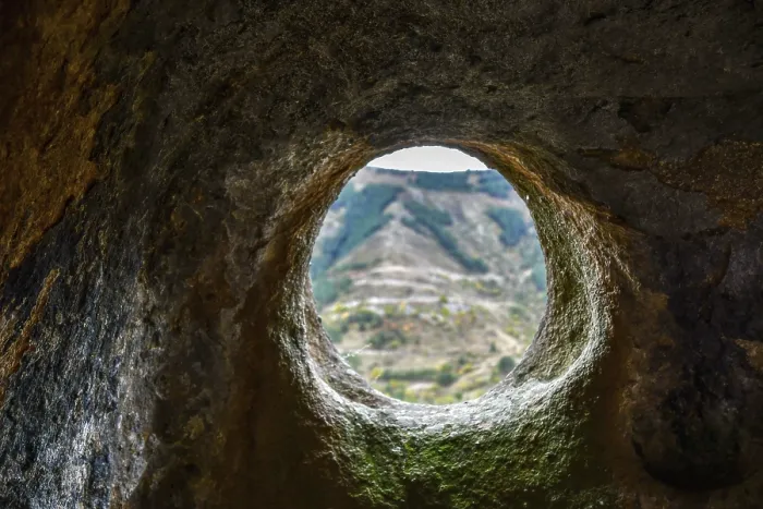 Framed Print : A window in a sandstone cave with a view of the opposite mountain Framed Print : A window in a sandstone cave with a view of the opposite mountain
