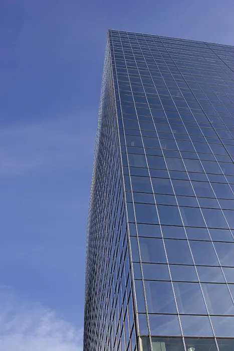 Framed Print : Windowed skycraper building against a blu sky with thin clouds Framed Print : Windowed skycraper building against a blu sky with thin clouds