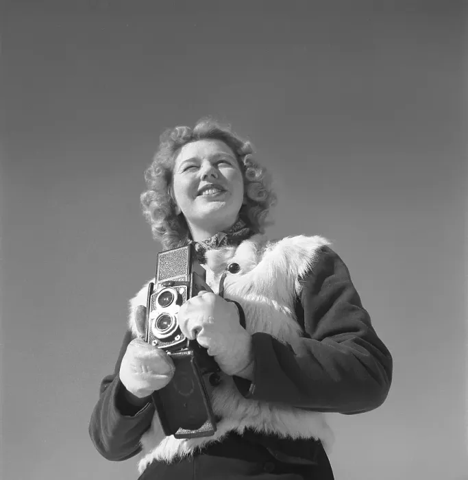 Framed Print : Winter in the 1940s. A young woman is photographing on a winter day