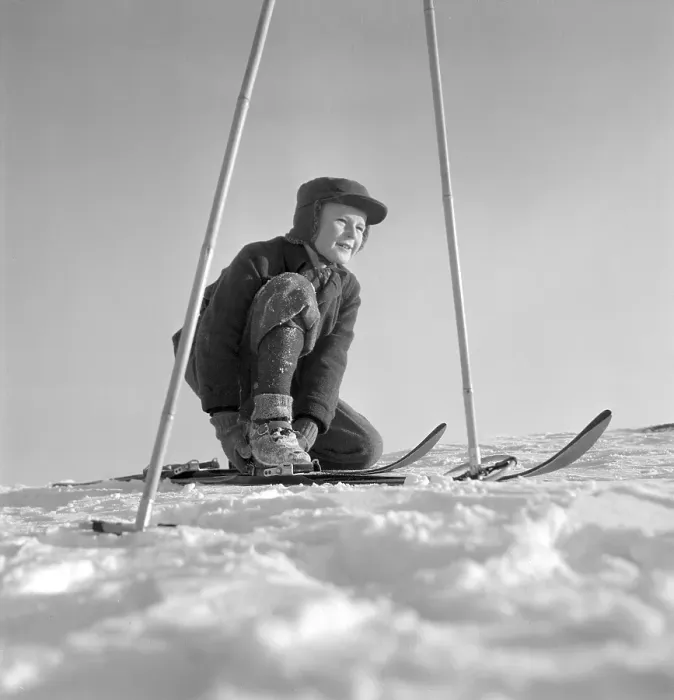 Framed Print : Winter in the 1950s. A boy is seen putting on his skis on a sunny winter day 1950 Framed Print : Winter in the 1950s. A boy is seen putting on his skis on a sunny winter day 1950