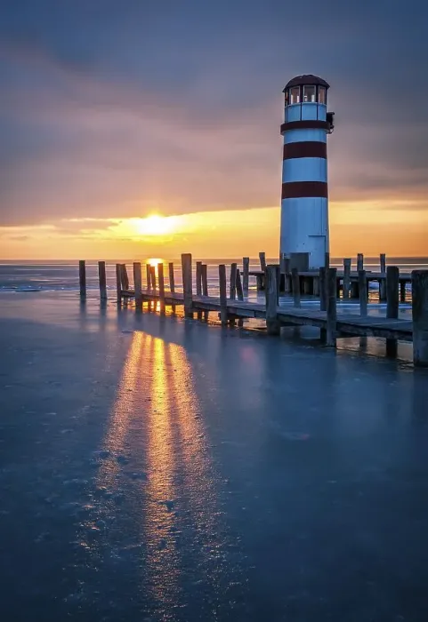 Framed Print : Winter landscape with lighthouse on a lake at sunset