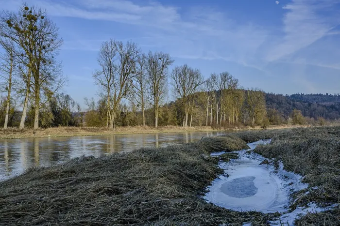 Framed Print : A wintry river flows near bare trees and hills Framed Print : A wintry river flows near bare trees and hills
