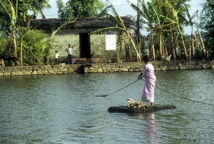 Framed Print : A woman crossing the Backwaters with the help of the rope and a country made float