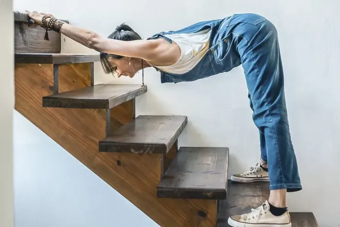 Framed Print : A woman doing stretching exercises on the stairs of her home Framed Print : A woman doing stretching exercises on the stairs of her home