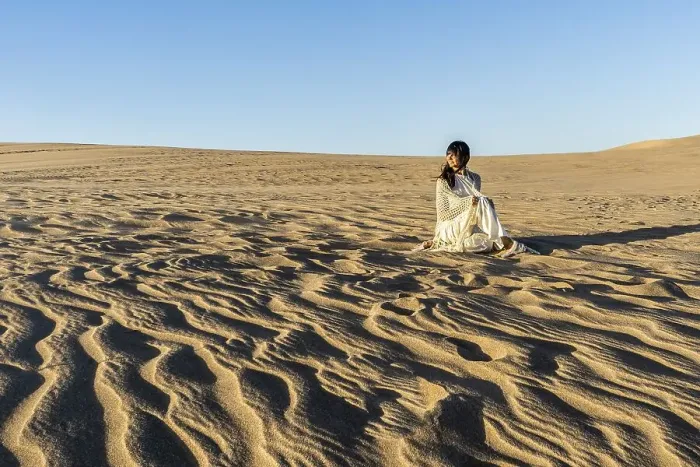 Framed Print : A woman dressed in white is watching the sunset on a dune