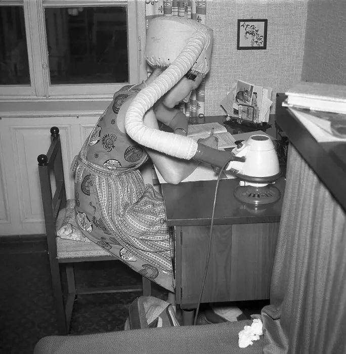 Framed Print : A woman dries her hair at the desk