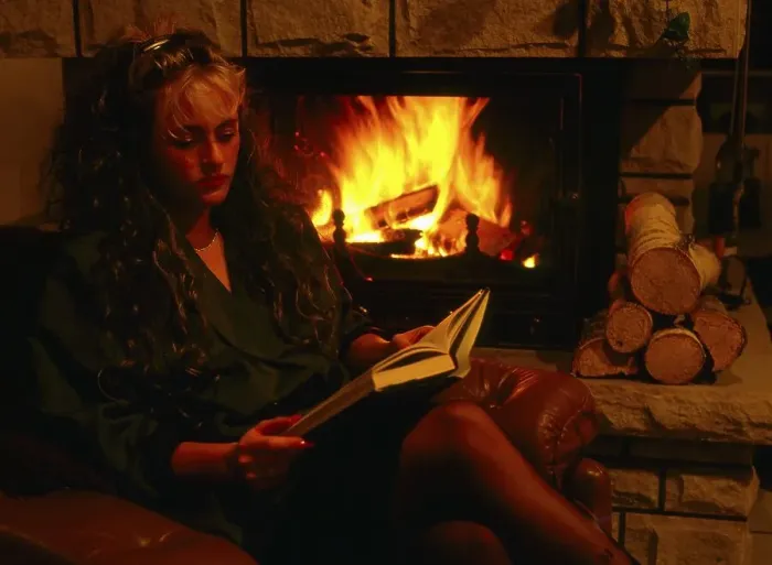 Framed Print : Woman by the fireplace, with book
