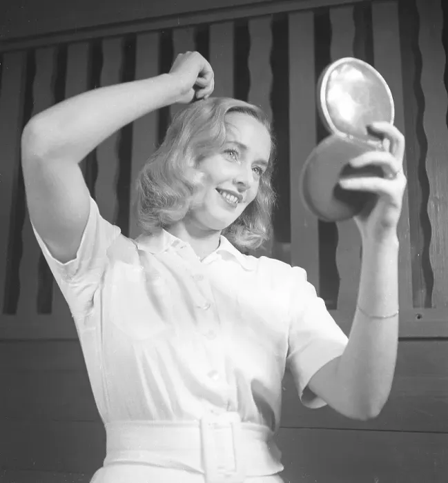 Framed Print : Woman fixing her hair in the 1940s Framed Print : Woman fixing her hair in the 1940s