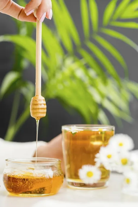 Framed Print : Woman holding glass with tea honey dipper