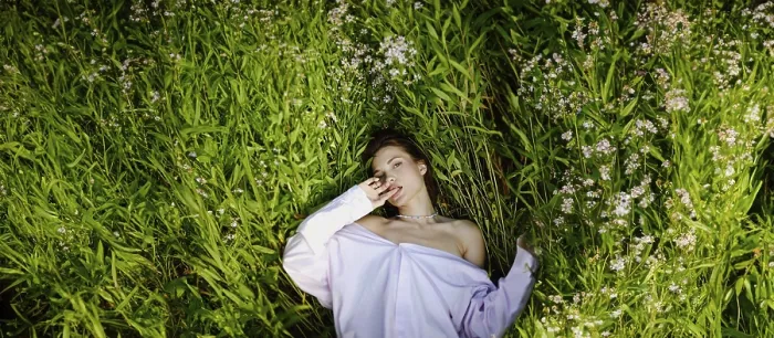 Framed Print : A woman lies in a field of green plants