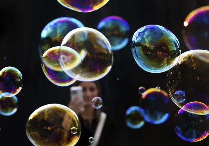 Framed Print : A woman photographs shimmering and floating soap bubbles against a black background Framed Print : A woman photographs shimmering and floating soap bubbles against a black background