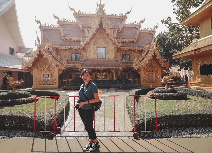 Framed Print : A woman posing in front of an ornate traditional thai temple with landscaped garden in Wat Rong Khun or White Temple