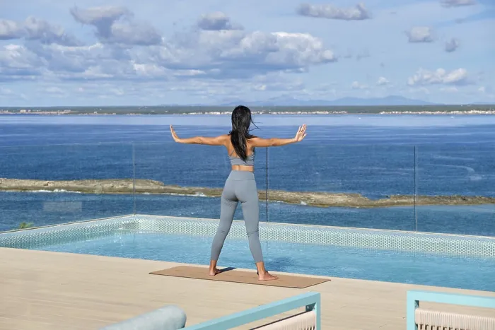 Framed Print : A woman practices yoga on a deck overlooking a serene ocean
