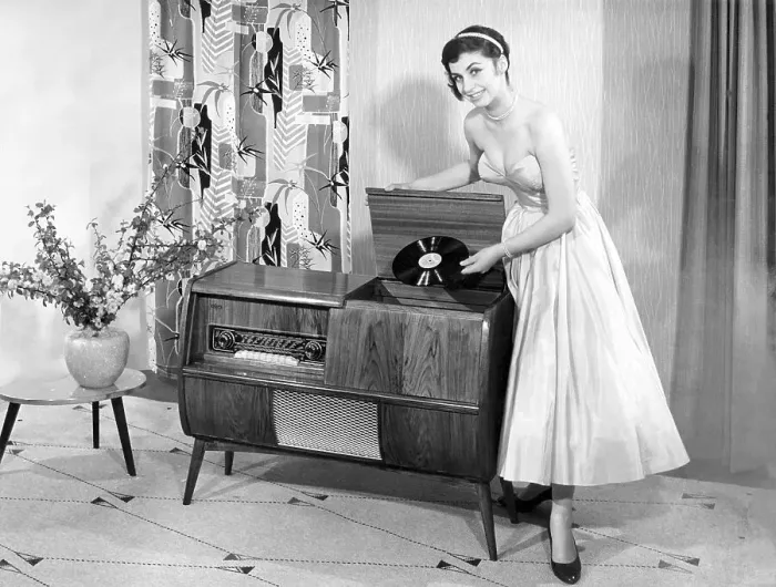 Framed Print : Woman in front of a record player in the living room
