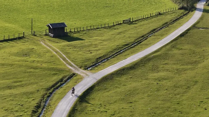 Framed Print : Woman riding an e-bike through the alpine landscape