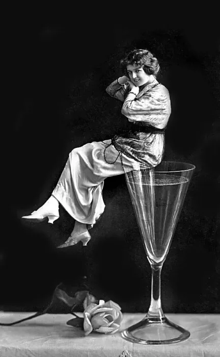 Framed Print : Woman sitting on a champagne glass