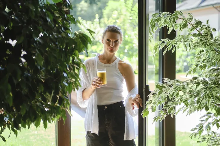 Framed Print : A woman stands in a doorway holding a glass of refreshing beverage Framed Print : A woman stands in a doorway holding a glass of refreshing beverage
