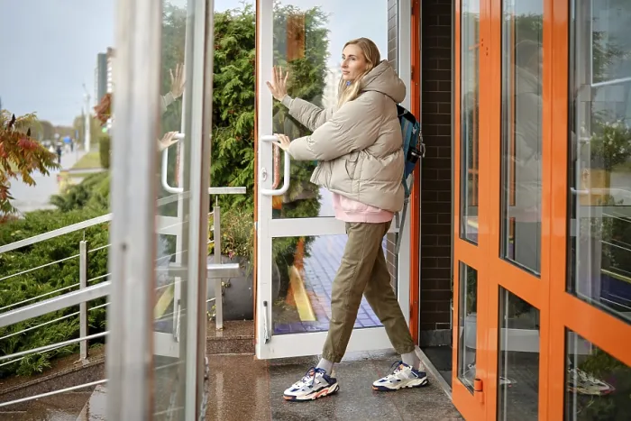 Framed Print : A woman steps out of a contemporary building on a cool day Framed Print : A woman steps out of a contemporary building on a cool day