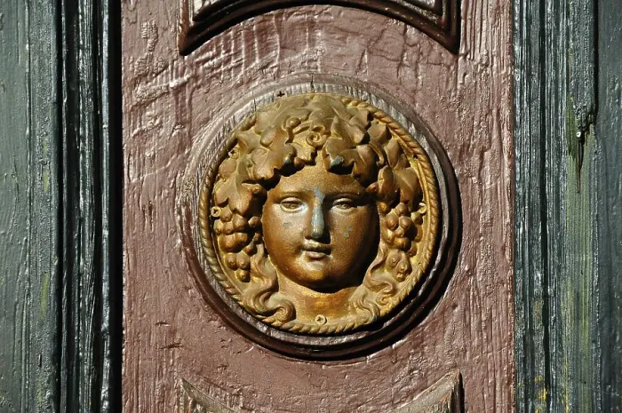 Framed Print : Womans head in relief on an old house door