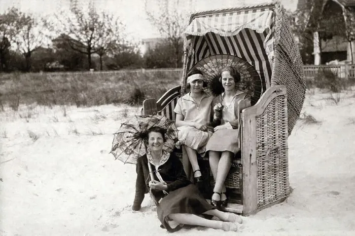 Framed Print : Three women on the beach, two sitting in beach chairs with sunshades