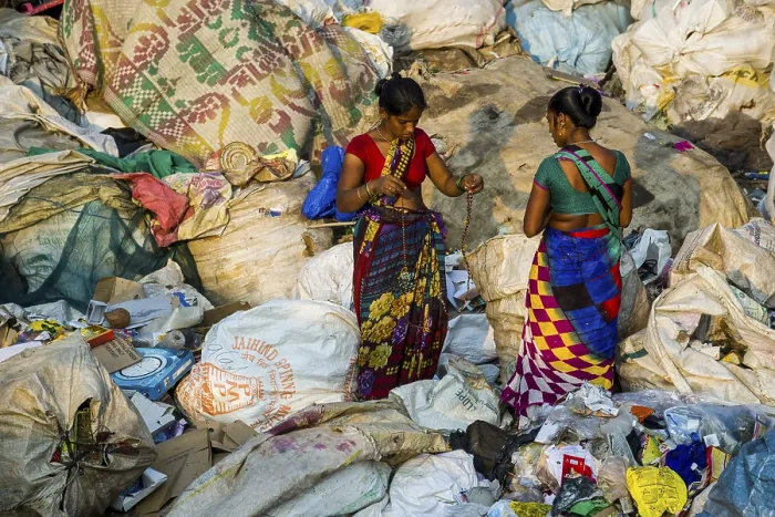 Framed Print : Two women in colorful saris are sorting out garbage for recycling