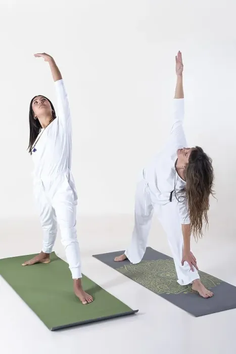 Framed Print : Two women dressed in white doing yoga over white background Framed Print : Two women dressed in white doing yoga over white background