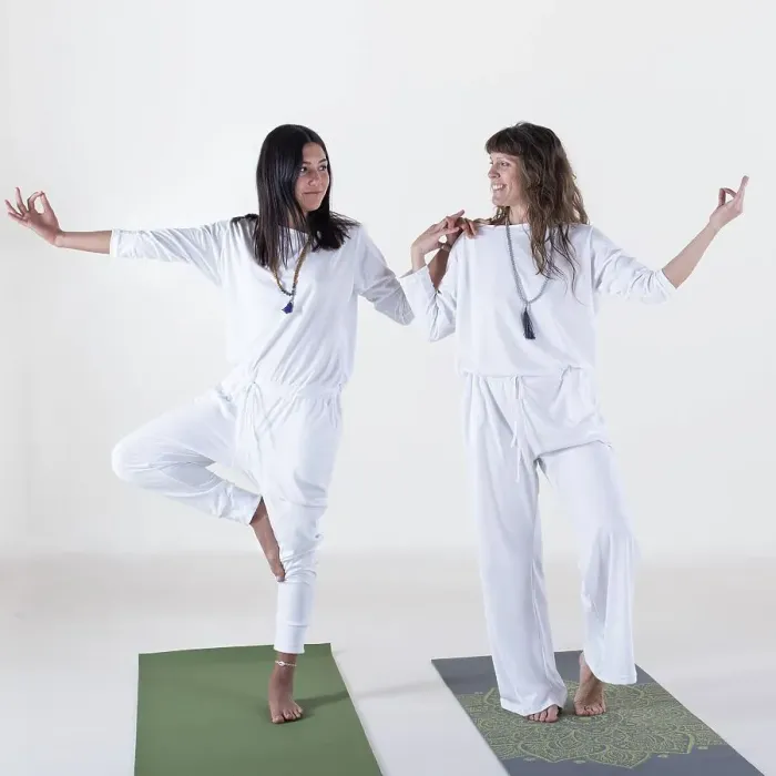 Framed Print : Two women dressed in white doing yoga over white background