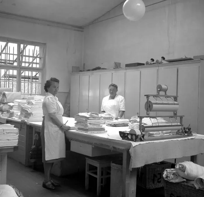 Framed Print : Women folding fabrics around 1950