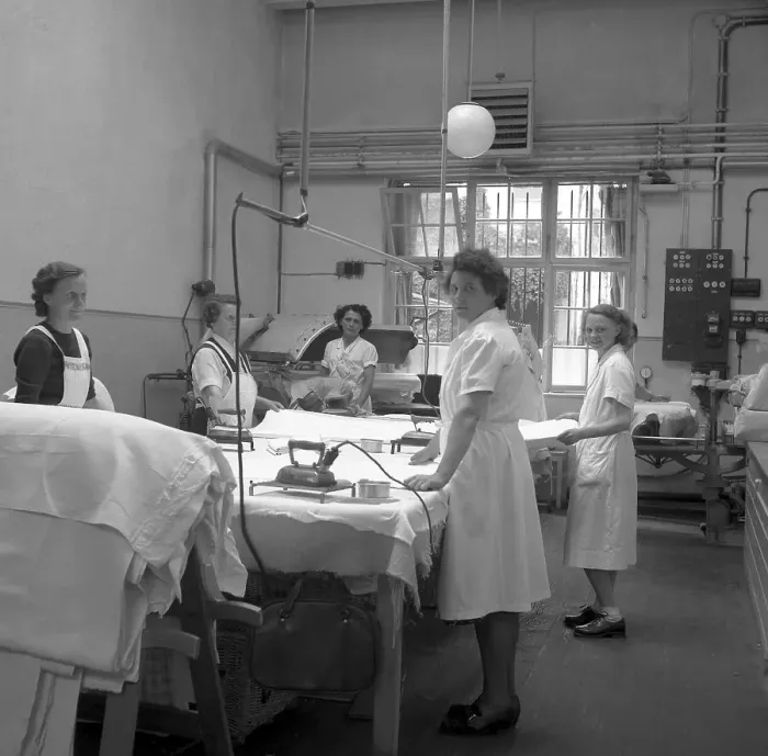 Framed Print : Women folding and ironing textiles