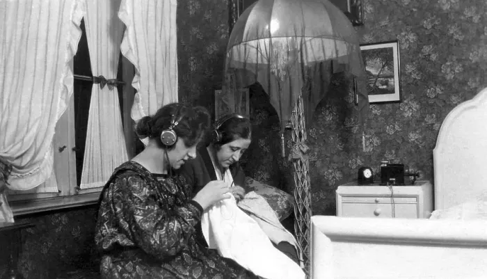Framed Print : Two women listening to radio with headphones