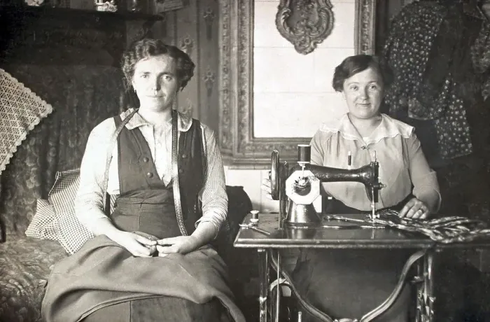 Framed Print : Two women work on the sewing machine