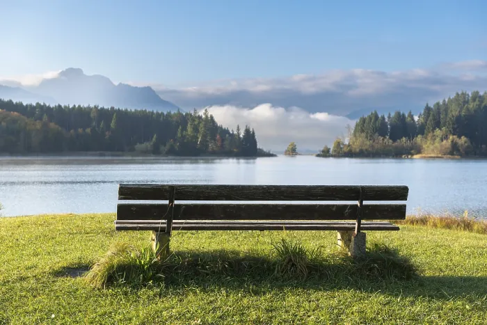 Framed Print : Wooden bench by the lake, surrounded by wooded surroundings and mountains