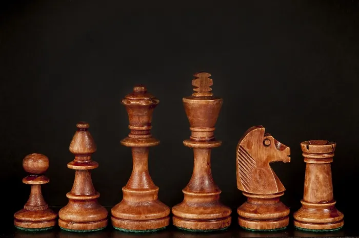 Framed Print : Wooden chess pieces lined up against a dark background