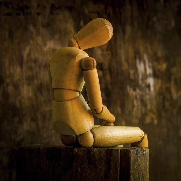 Framed Print : A wooden mannequin is positioned on a rough wooden surface Framed Print : A wooden mannequin is positioned on a rough wooden surface