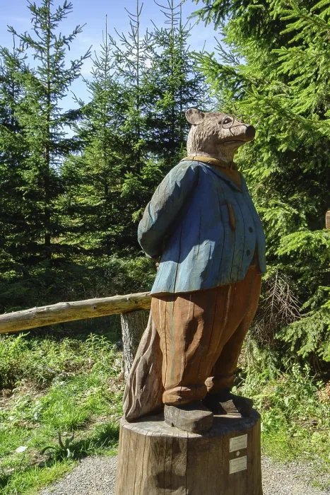 Framed Print : A wooden sculpture of a fox stands in the forest