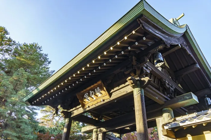 Framed Print : Wooden torii structure at a Japanese temple surrounded by trees and clear skies