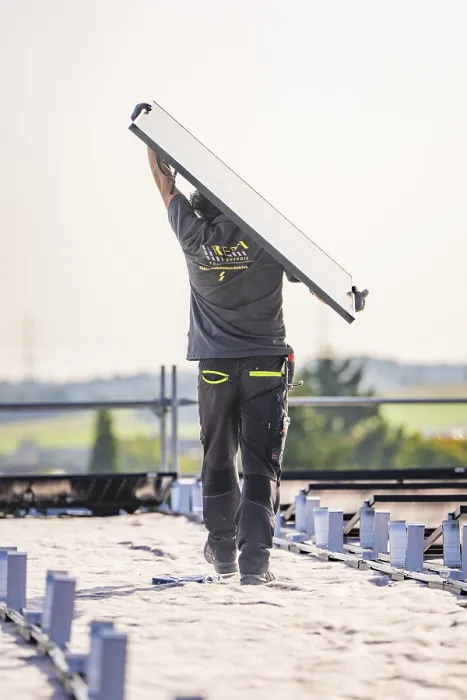 Framed Print : Worker carrying solar panel on a sunny roof Framed Print : Worker carrying solar panel on a sunny roof
