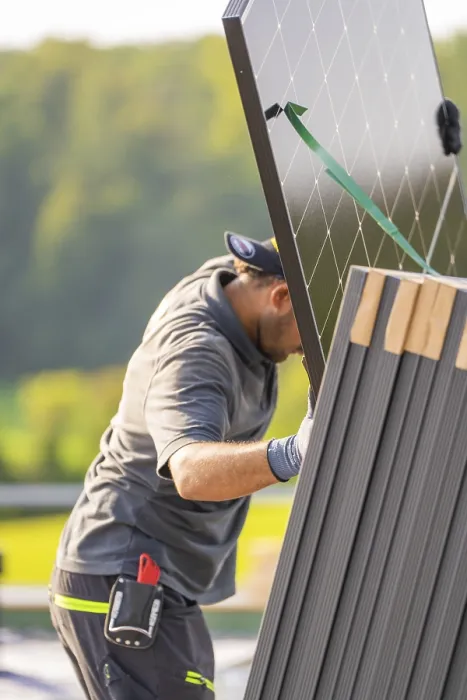 Framed Print : Worker positions solar panel with modern technology