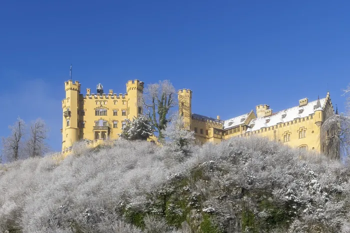 Framed Print : Yellow castle on a hill with snow-covered trees under a clear blue sky Framed Print : Yellow castle on a hill with snow-covered trees under a clear blue sky