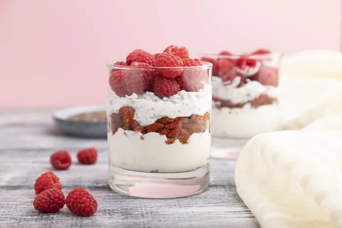Framed Print : Yogurt with raspberry, goji berries and chia seeds in glass on gray wooden background and linen textile