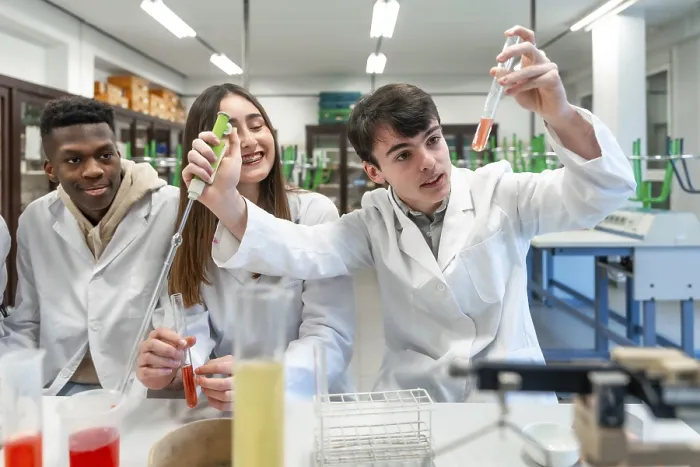 Framed Print : Young chemistry students wearing lab coats performing experiment using test tubes and other laboratory equipment Framed Print : Young chemistry students wearing lab coats performing experiment using test tubes and other laboratory equipment