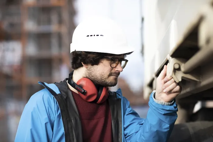 Framed Print : Young engineer wearing a helmet and hearing protection at a work site outside on a construction site