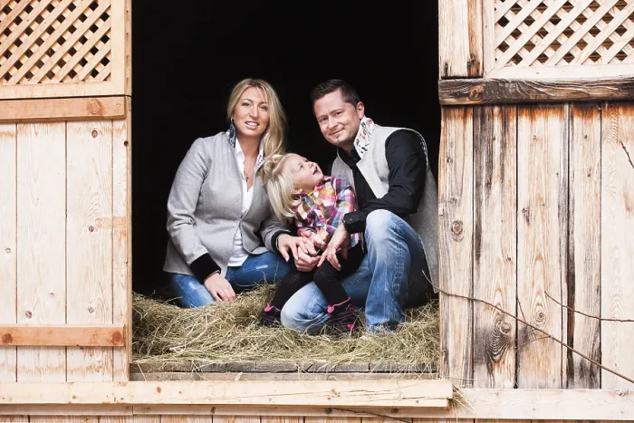 Framed Print : Young family sitting in the hay barn