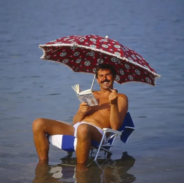 Framed Print : Young man with solar chair and sunshade on the beach Framed Print : Young man with solar chair and sunshade on the beach